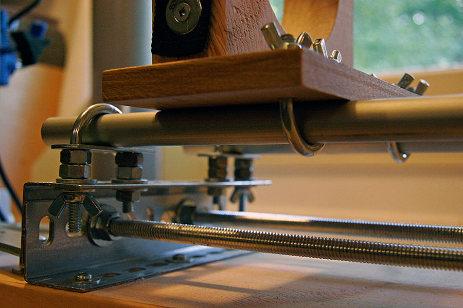 The 9/16" aluminum slide rods are held firmly in place by elevated U-bolts. <br />The movable platform on top is also attached to the <br />aluminum slide rods with inverted U-bolts.